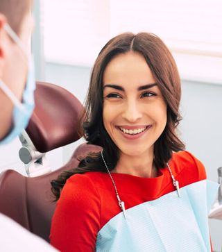 Image of a female patient at her dental clinic about to under go a regular check-up and clean with her dentist.