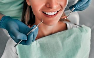 Image of a female having her teeth cleaned by a dentist.