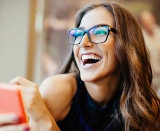 Stock image of female enjoying booking her online dental appointment with a white smile.
