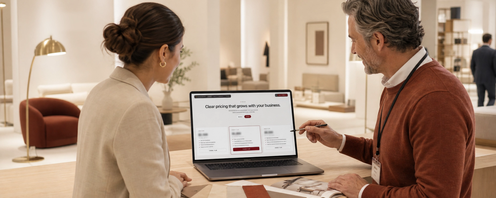 A SuperCat rep and a dealer reviewing pricing on a laptop at a showroom counter.