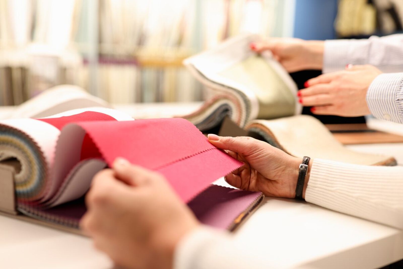 A customer and a sales rep leafing through upholstery fabric swatch books at a showroom table