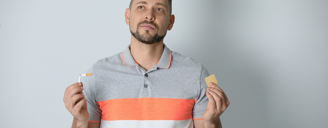 Man snapping cigarette and holding nicotine patch