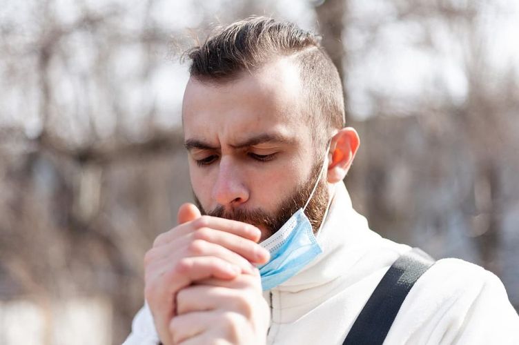 Man smoking with a face mask on