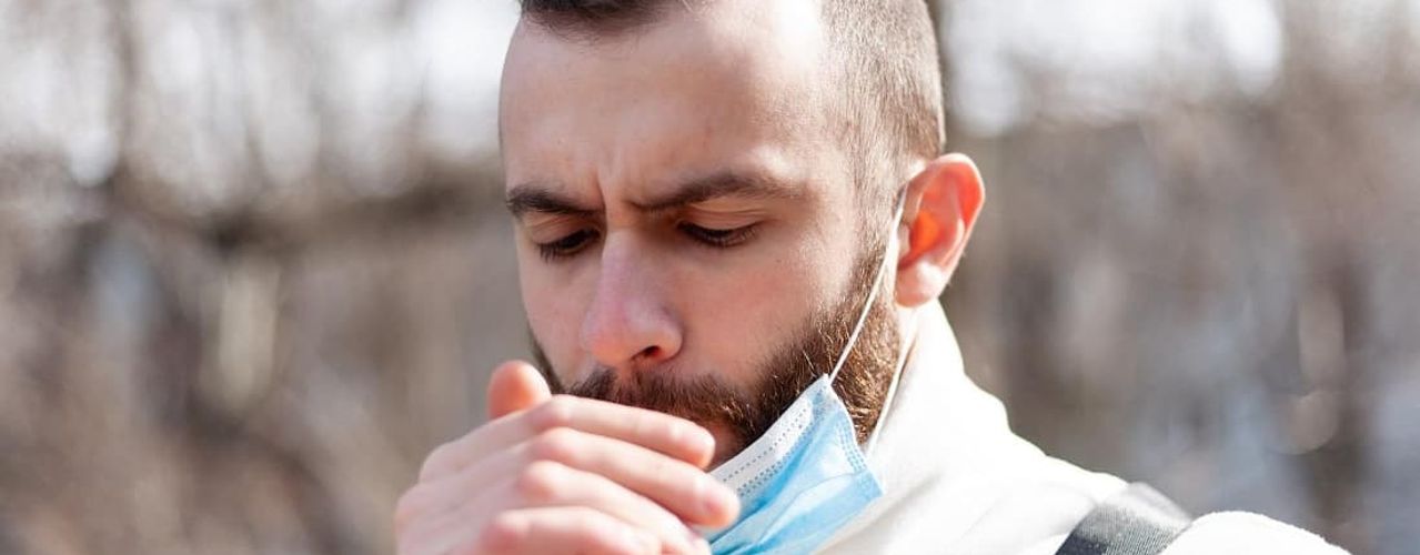 Man smoking with a face mask on