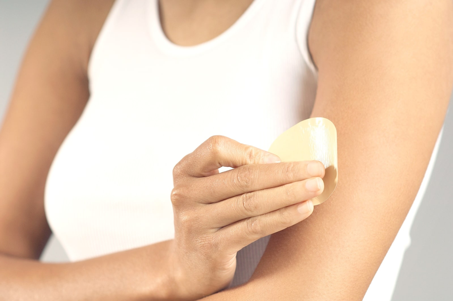 Lady applying Nicotine Patch to Arm