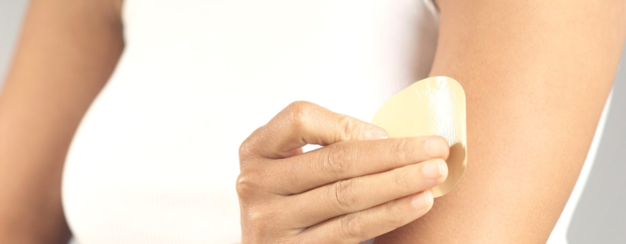 Lady applying Nicotine Patch to Arm