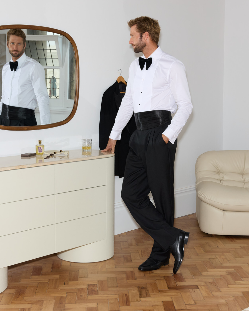 Man looking in the mirror wearing black dress shoes