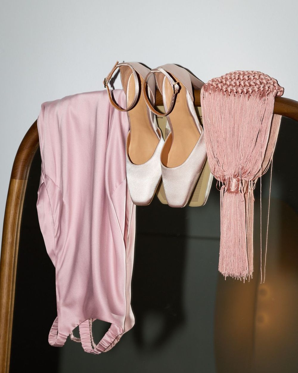 Pair of blush pink heels with a pink dress and pink fringe detail