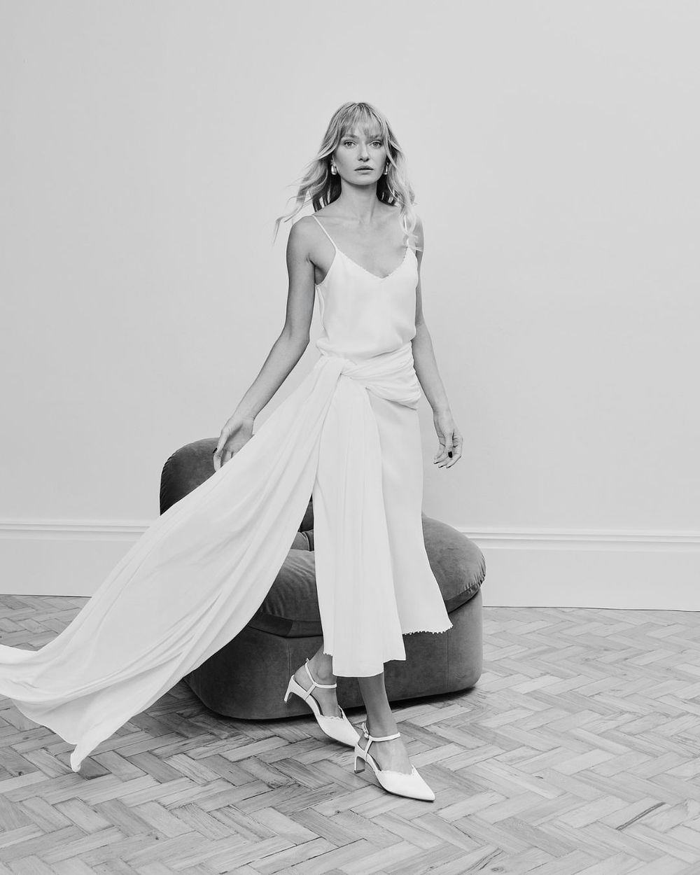 Black and white image of a model with white satin heels