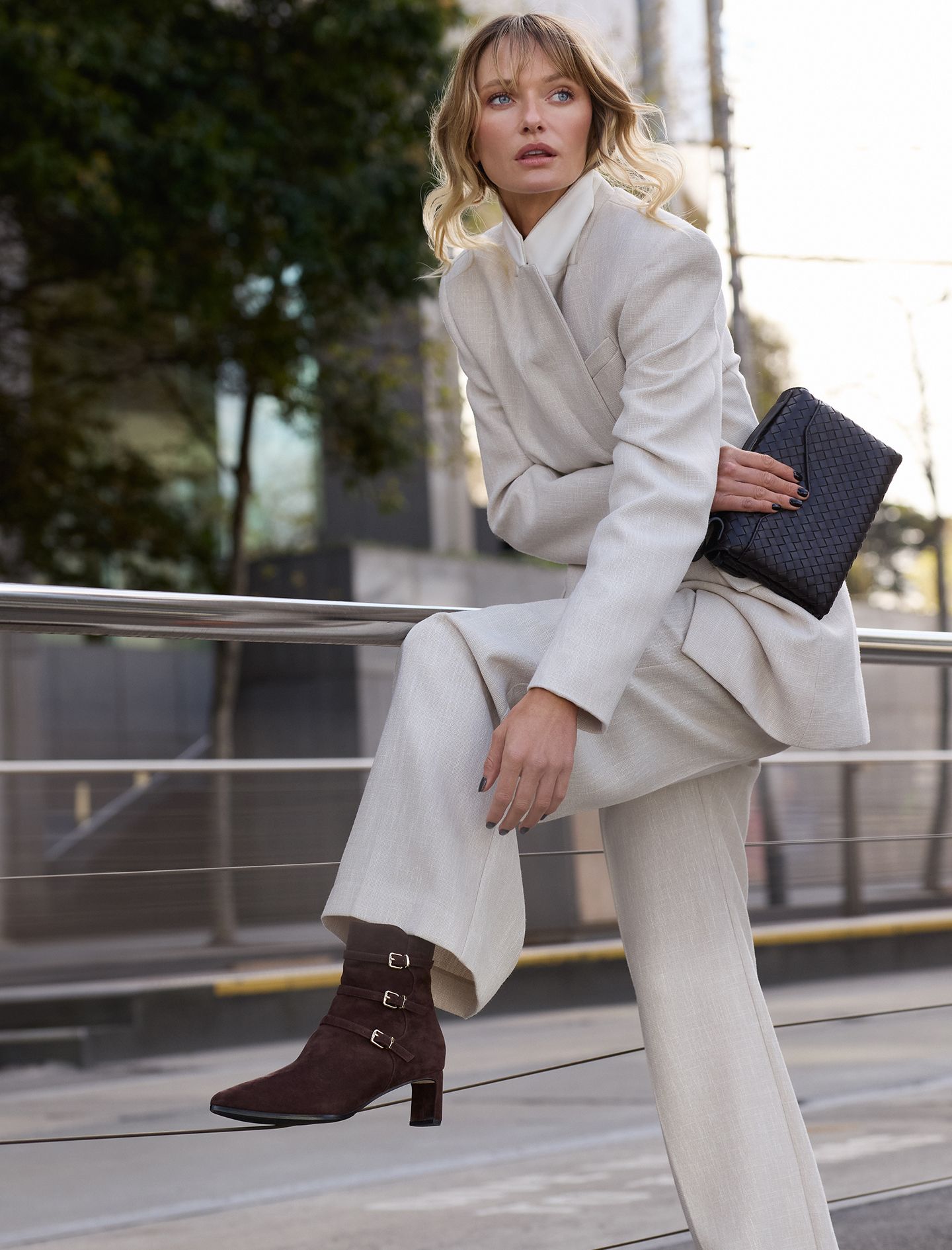 Woman wearing brown suede boots and a white suit