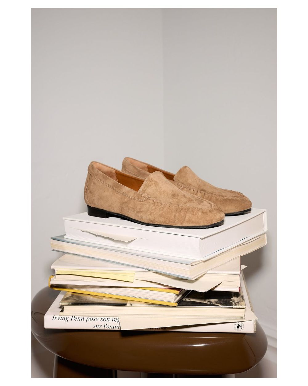 Pair of suede loafers on a stack of books