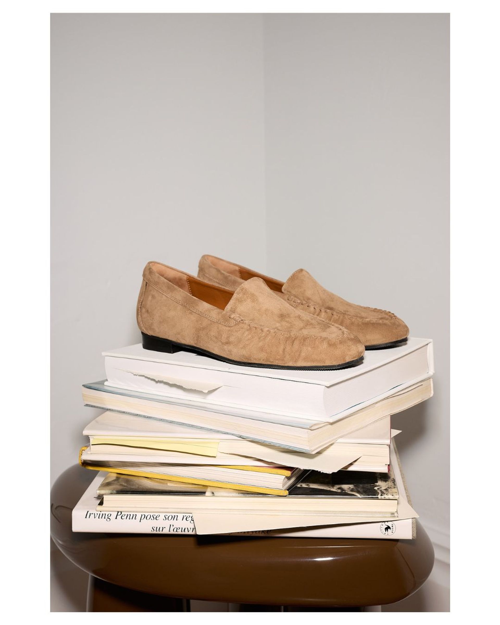 Pair of suede loafers on a stack of books