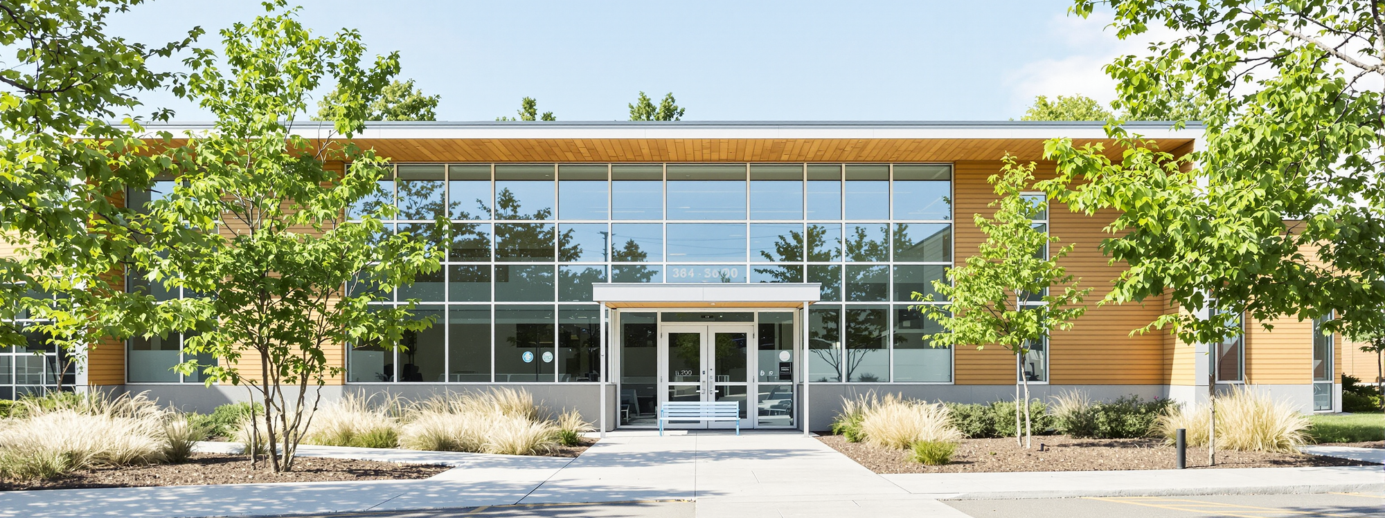 A modern single-storey school building with large windows and a planted courtyard