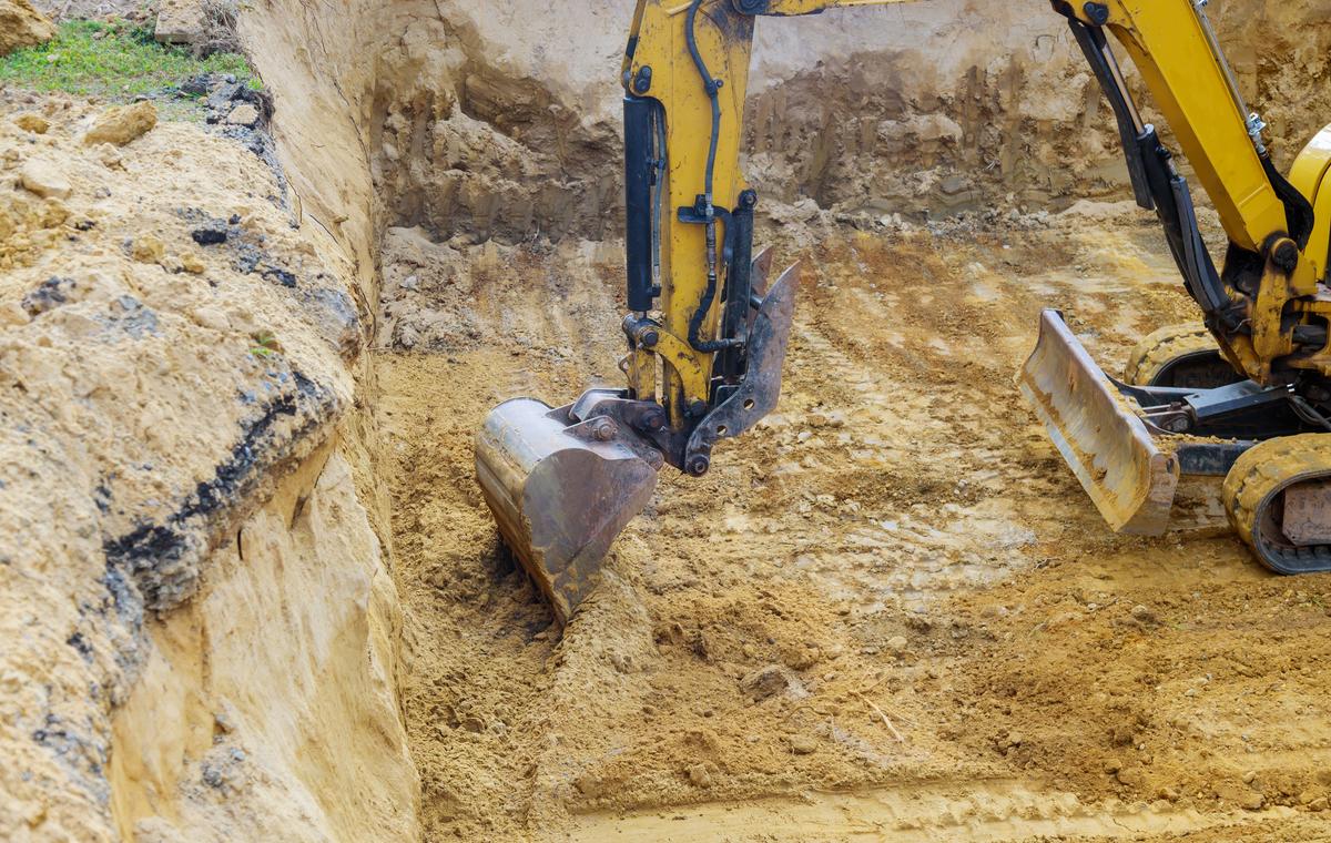 Excavator performing precision excavation and trenching for site preparation at a construction project in Sydney, NSW.