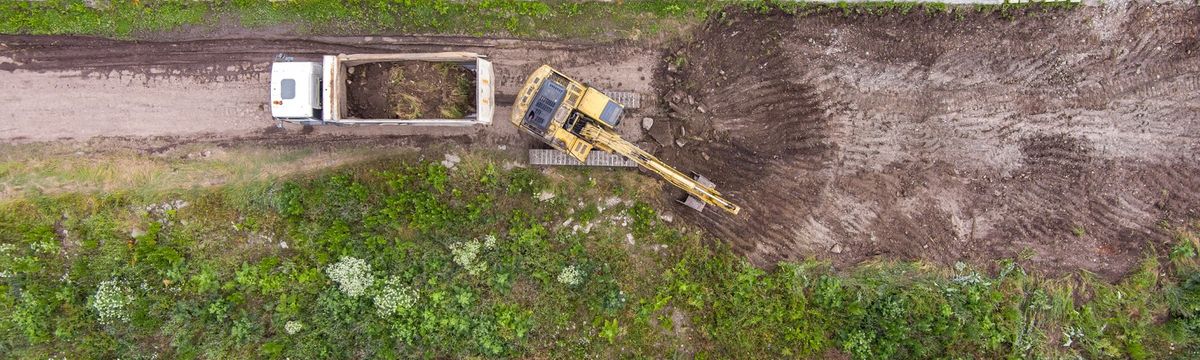 Professional land clearing services in Sydney with excavator removing vegetation and preparing a development site.