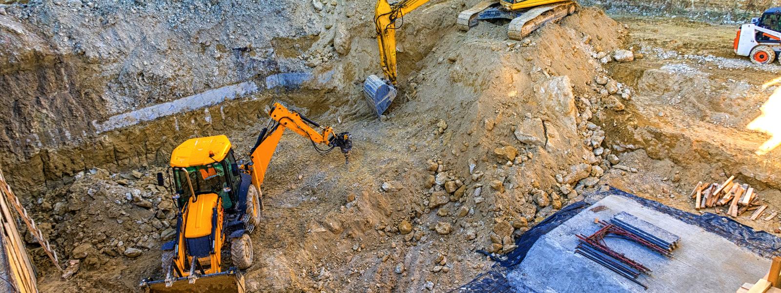 Excavator and earthmoving equipment performing professional excavation services at a construction site in Sydney, NSW.