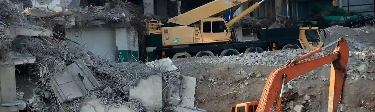 Hydraulic breaker demolishing reinforced concrete and steel rebar during a commercial demolition project in Sydney, NSW.
