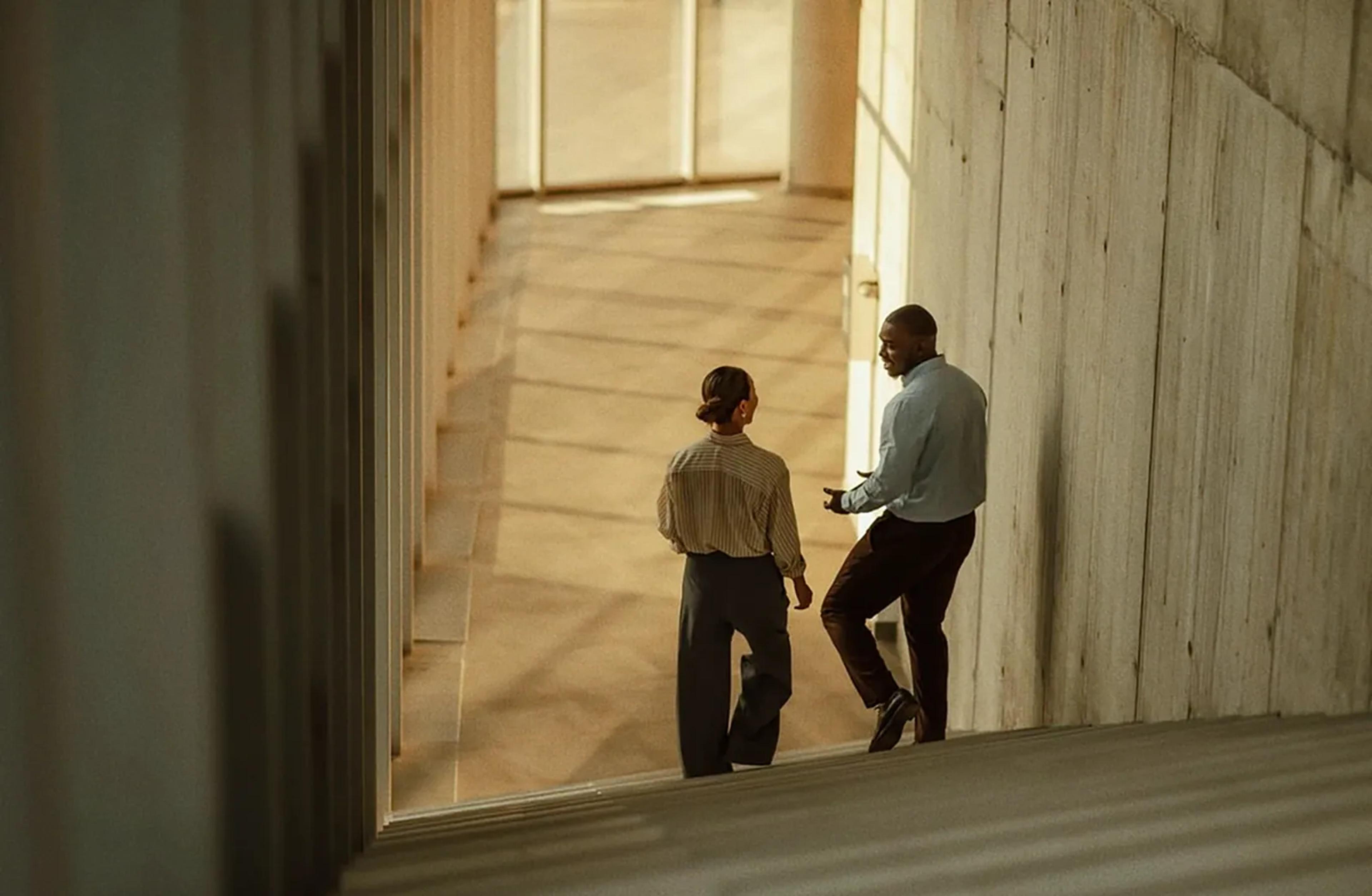 Two colleagues talking on a sunlit staircase