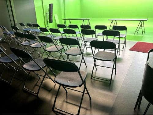 Des chaises en rangs sont installées dans l’espace fond vert d’Hacienda Studio