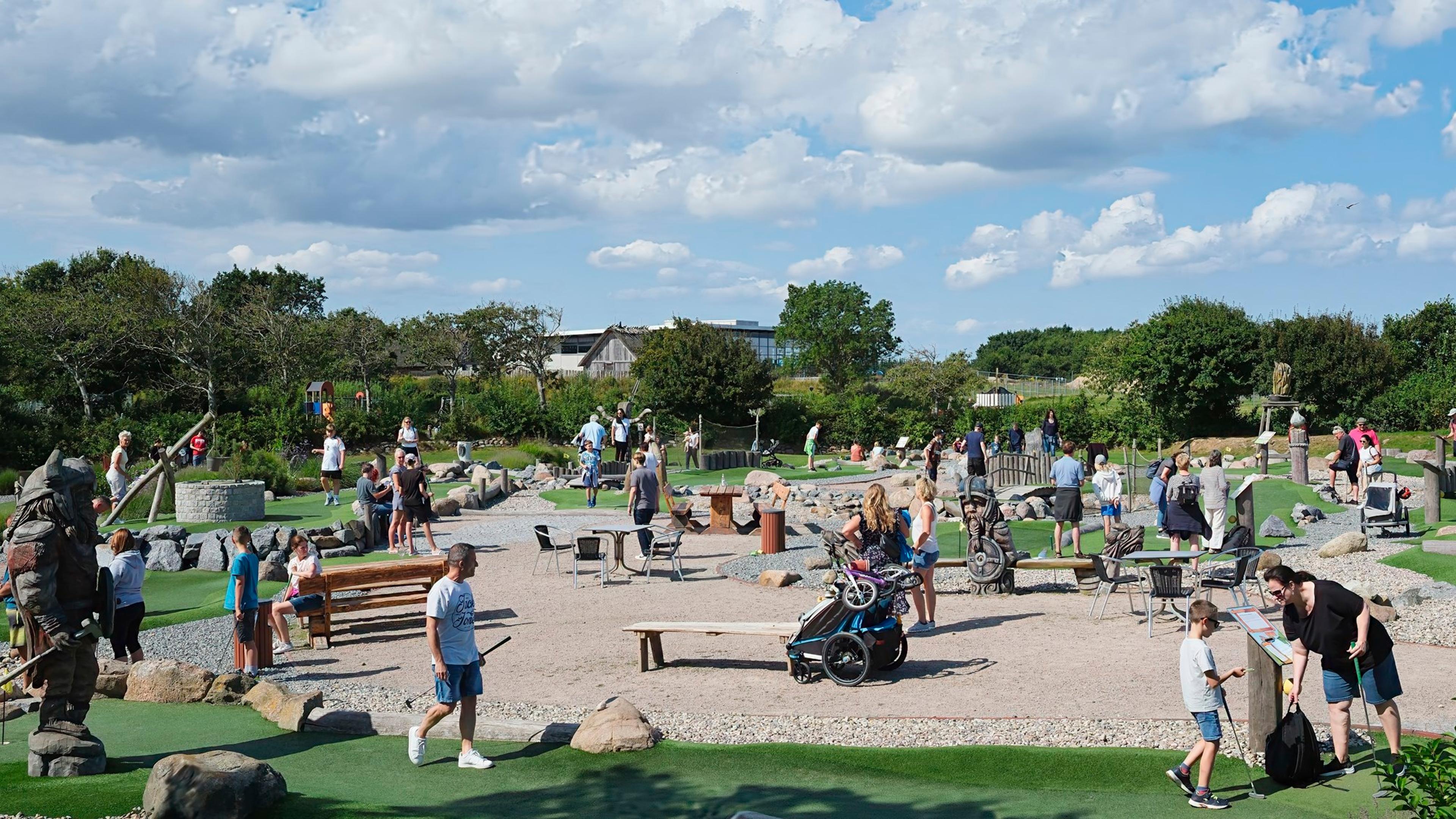 Ein Minigolfplatz mit einem pinken Ball und einem Schläger auf grünem Kunstrasen