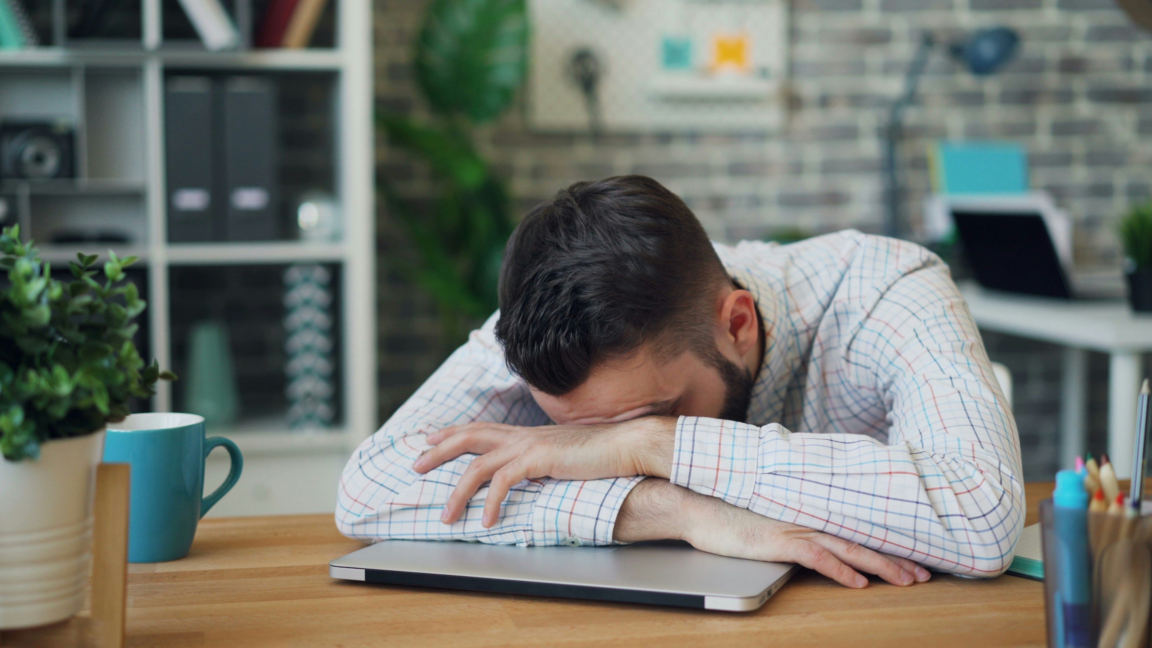 A person sleeping on a laptop