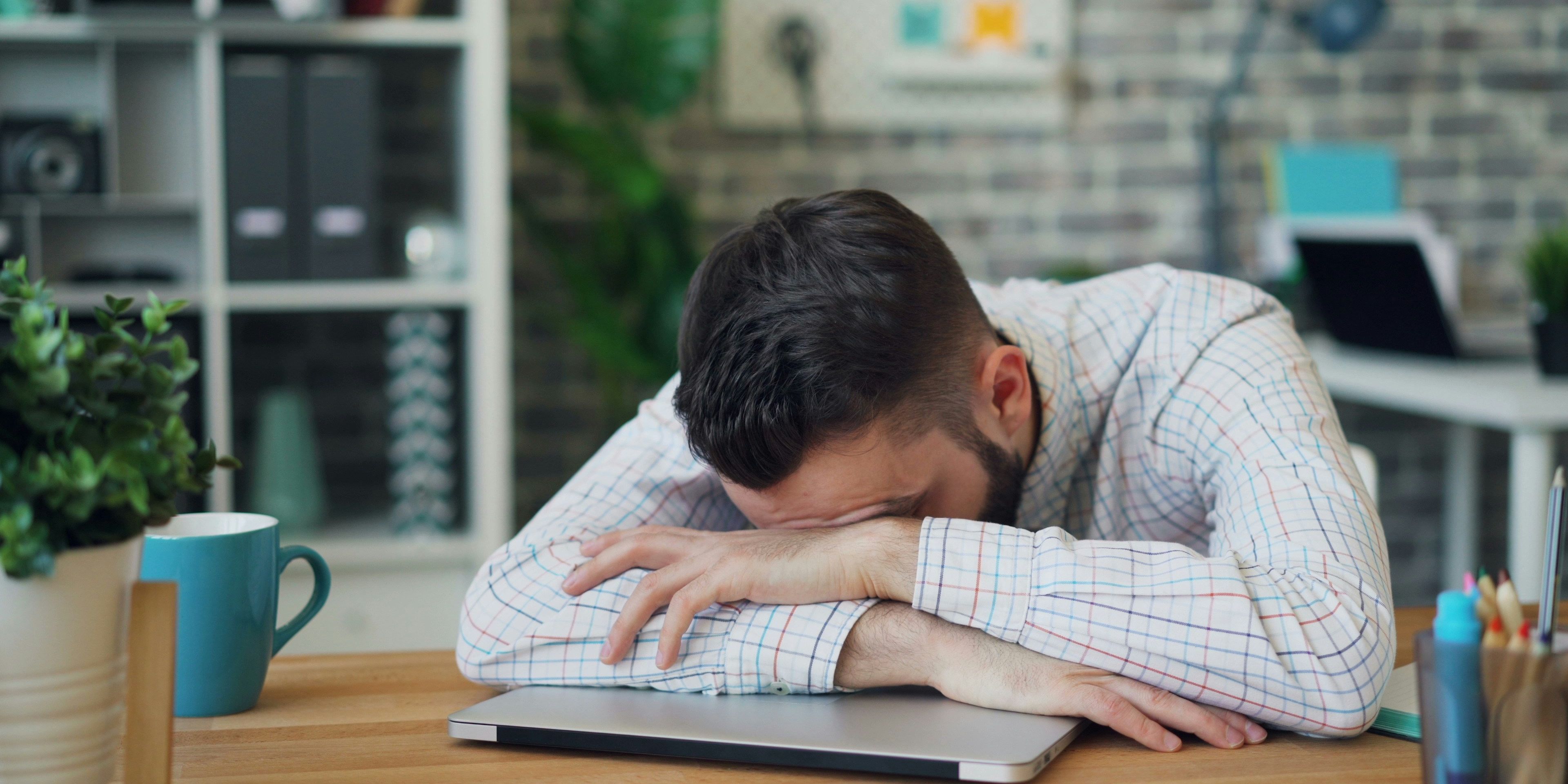 A person sleeping on a laptop