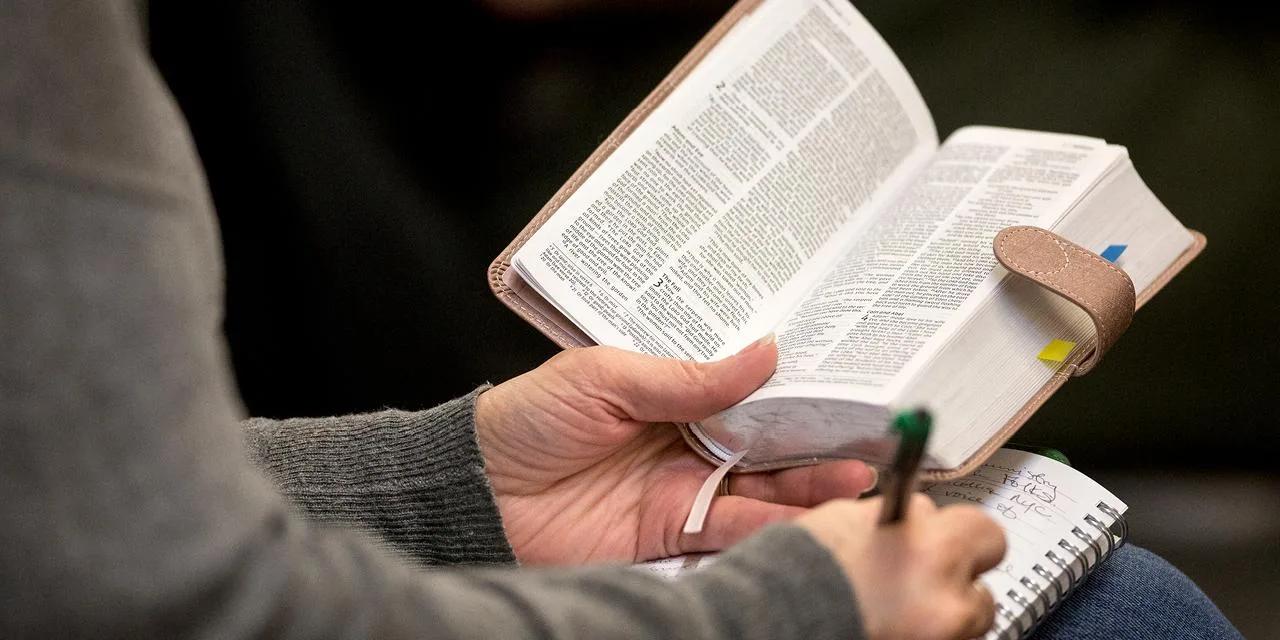 Hands holding open Bible during study