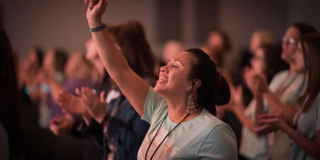 Woman worshipping with hands raised