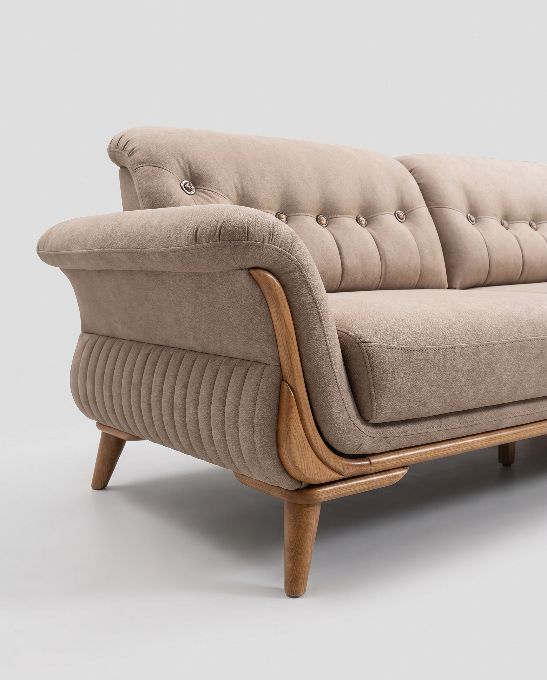 Kaprije sofa, krupno na levom kraju: traka u tonu drveta zalazi uz čelo rukonaslona i gubi se pod šavom, pod njom druga traka i noga, a strana tela je kanelirana