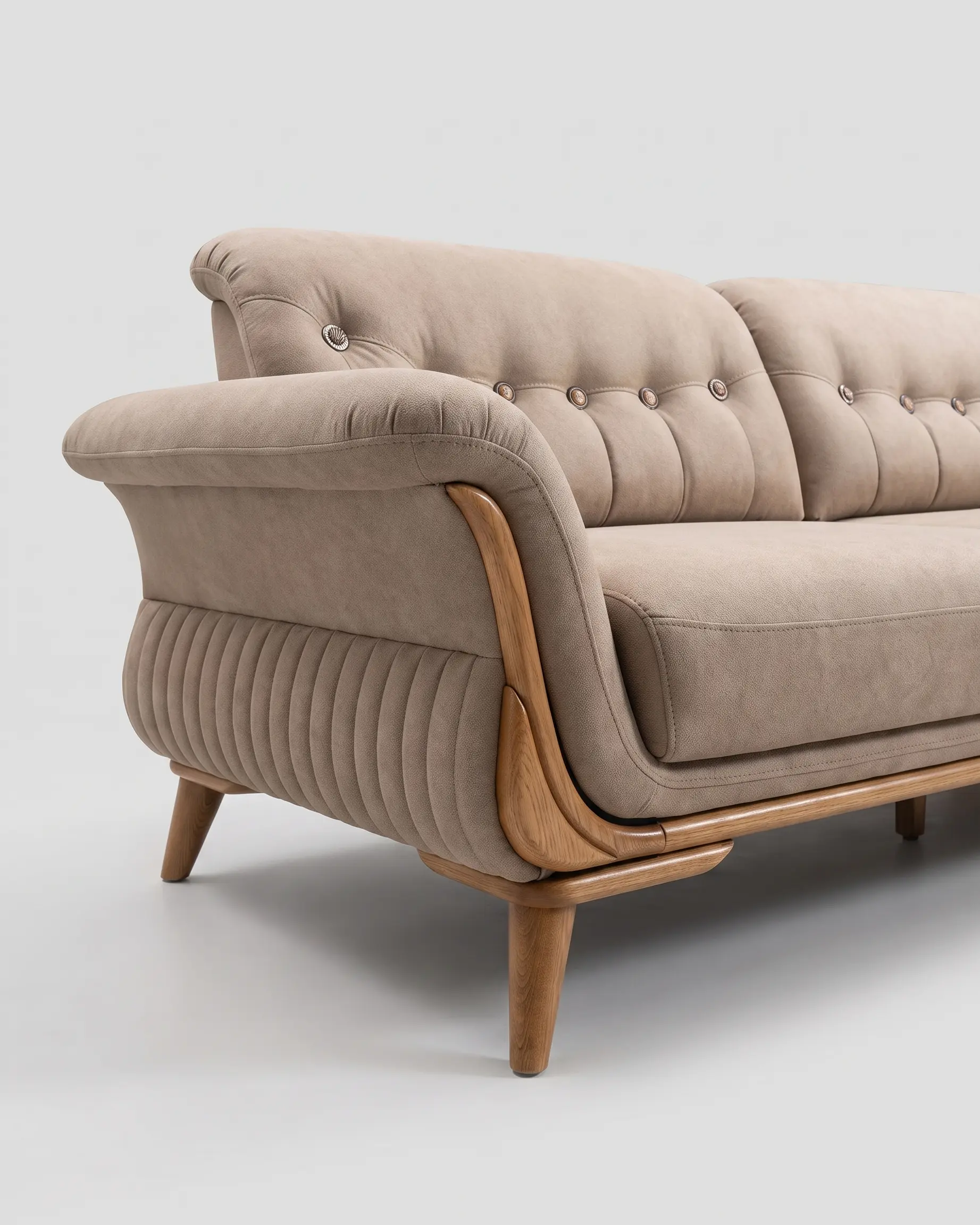 Kaprije sofa, krupno na levom kraju: traka u tonu drveta zalazi uz čelo rukonaslona i gubi se pod šavom, pod njom druga traka i noga, a strana tela je kanelirana