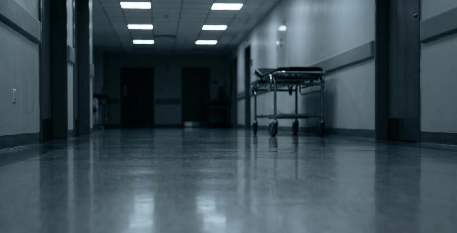 An empty, dimly lit hospital corridor representing organ procurement negligence and end-of-life medical oversight.