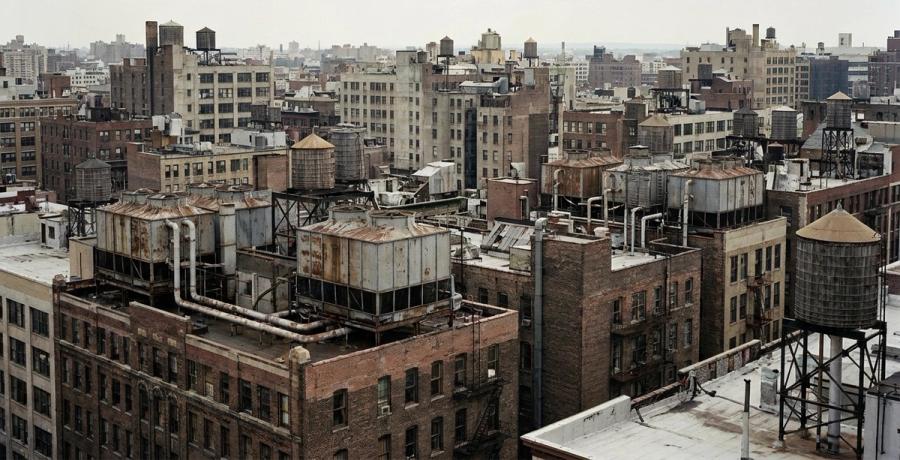 Rooftop cooling towers against a city skyline.