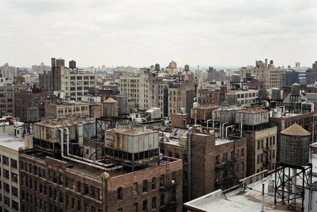 Rooftop cooling towers against a city skyline.
