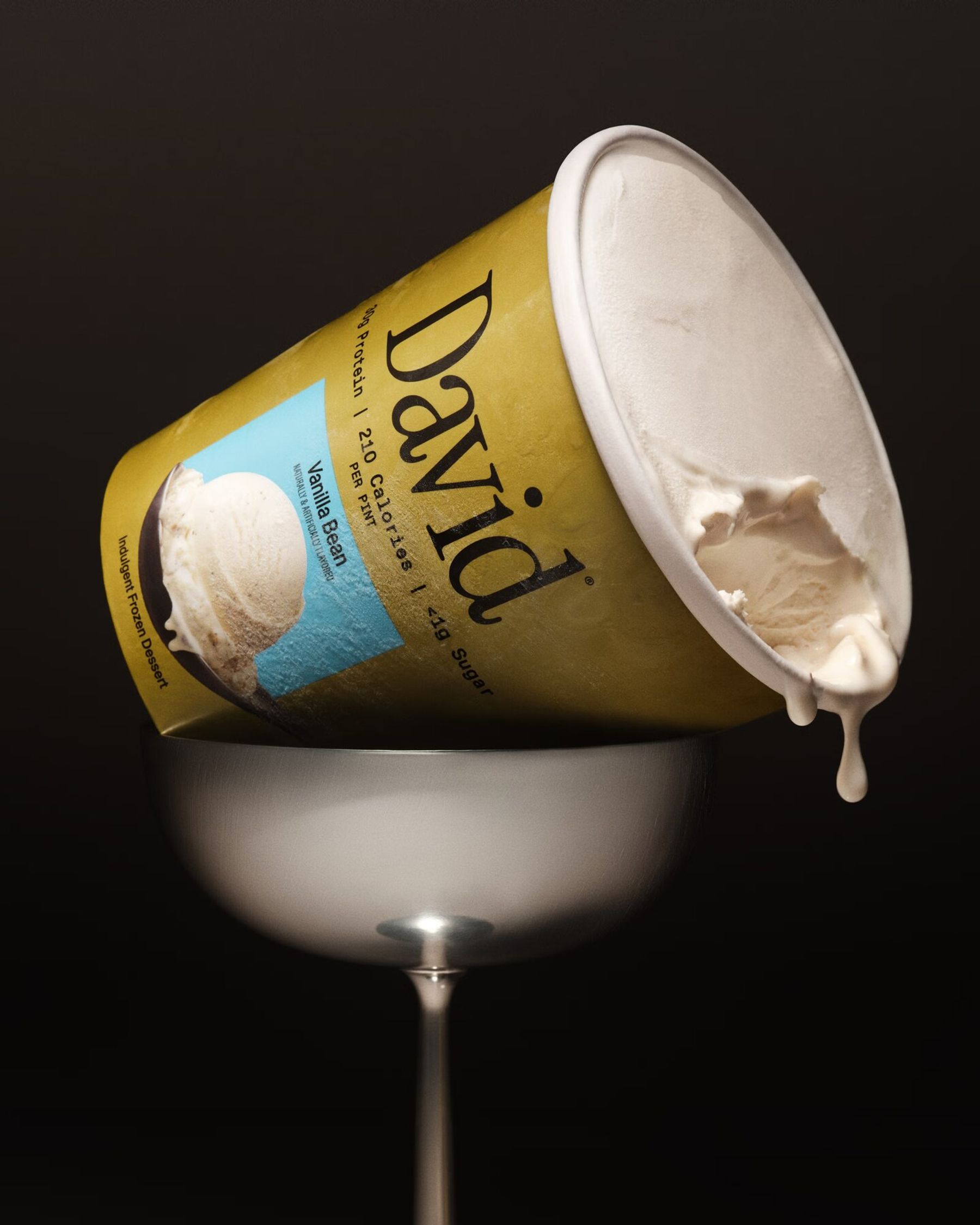 A tipped pint of David Vanilla Bean protein ice cream resting on a silver coupe