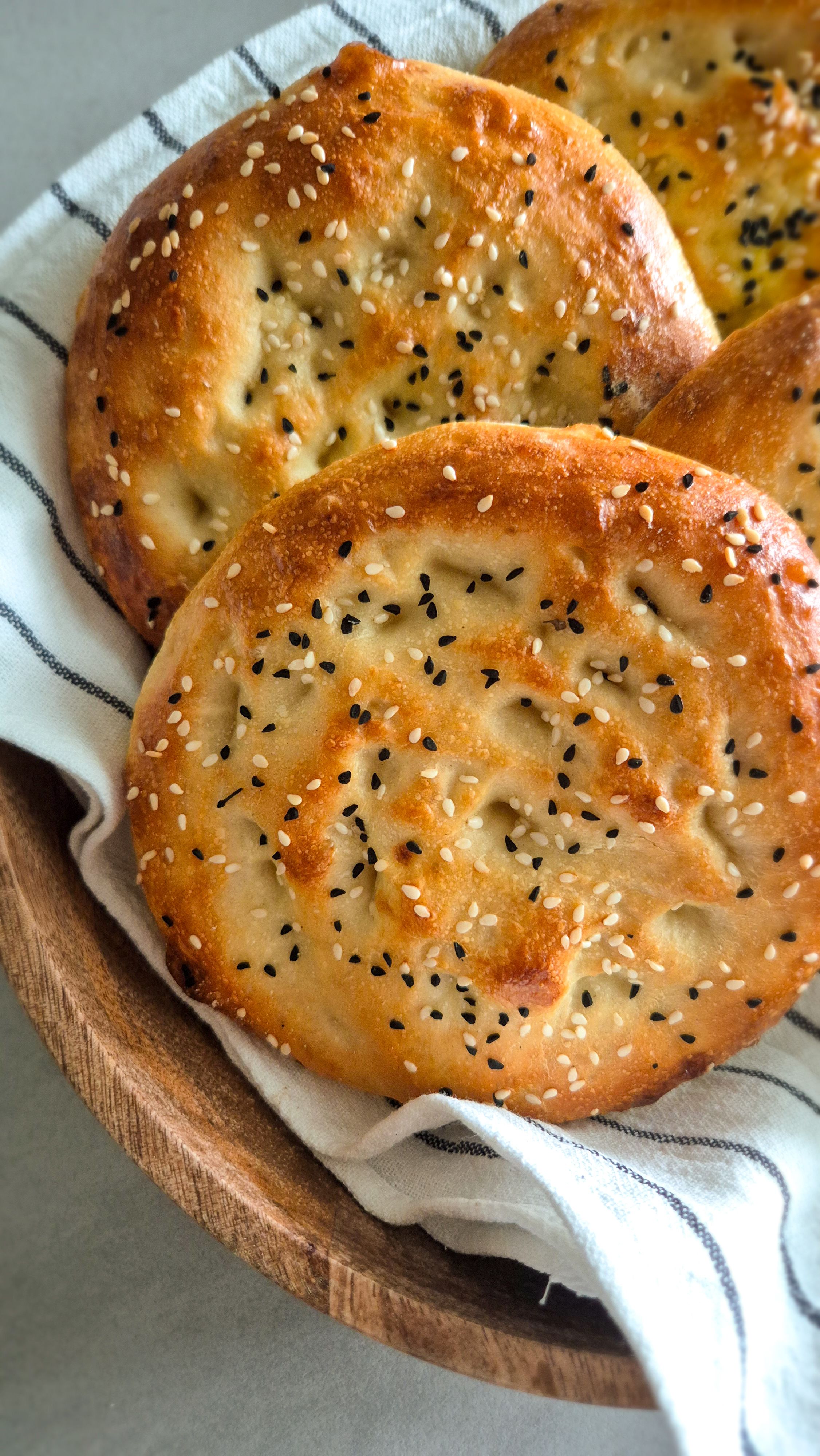 Authentisches türkisches Fladenbrot mit Sesam und Schwarzkümmel in einer Schale mit einem Tuch umwickelt.