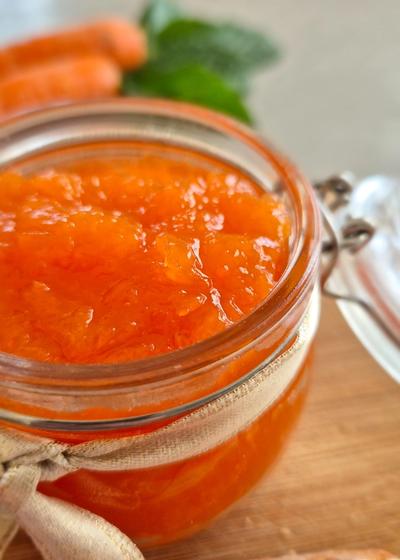 Ein dekorativ angerichtetes Glas Hasenfrühstück (Karotten-Apfel-Marmelade) auf einem Ostertisch.