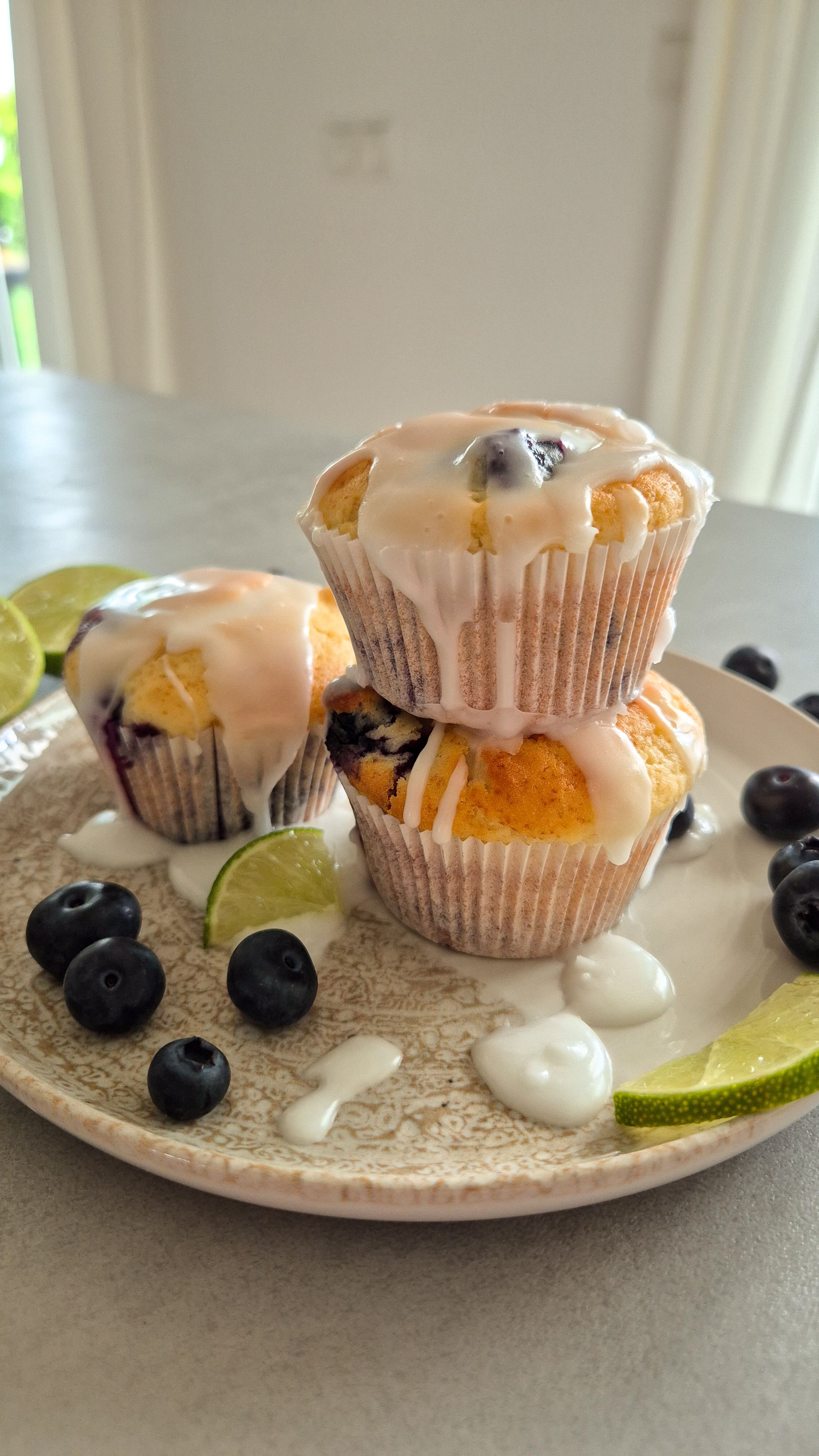 Saftige Zitronen-Heidelbeer-Muffins mit Joghurt auf einem Teller serviert.