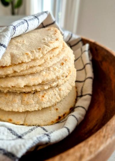 Gold der Maya: Mexikanische Maistortillas in einem Tuch gewickelt in einer Holzschale.