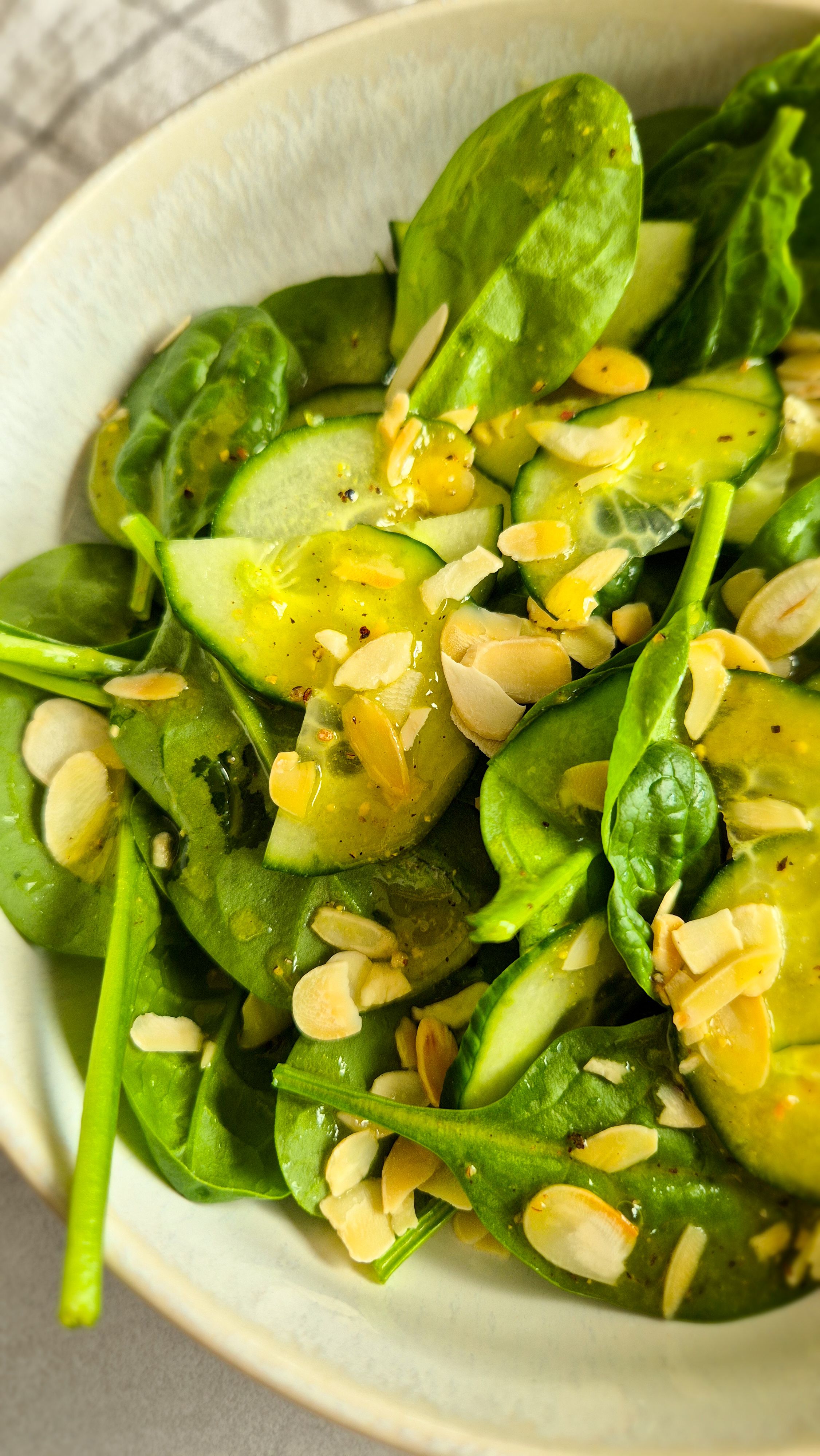 Ein erfrischender Blattsalat mir Gurken und Dressing in einer Schale zu Pasta. 