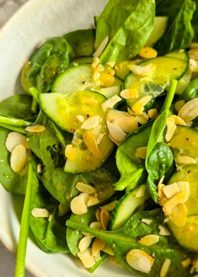 Ein erfrischender Blattsalat mir Gurken und Dressing in einer Schale zu Pasta.