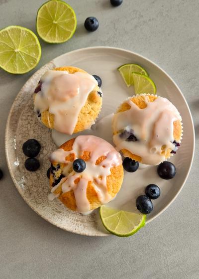 Saftige Zitronen-Heidelbeer-Muffins mit Joghurt auf einem Teller serviert.