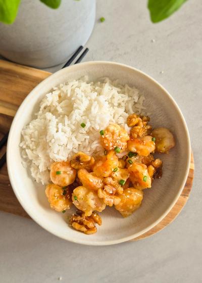 Garnelen mit Walnüssen in einem knusprigen Honig-Mantel zu Reis serviert.