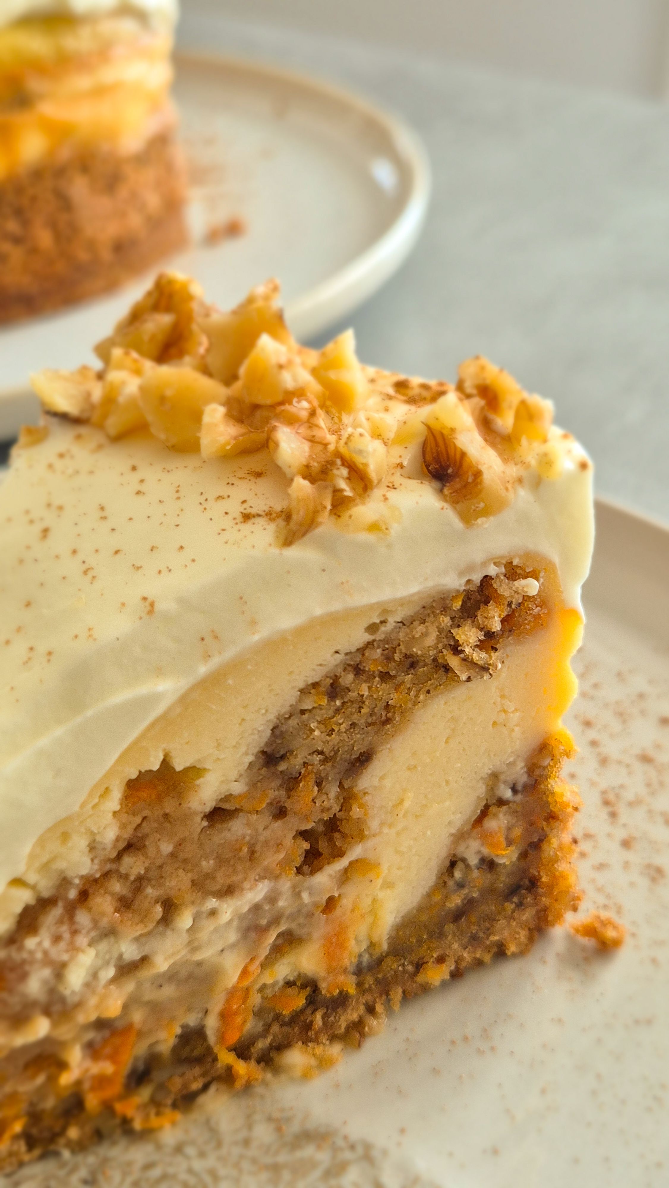Cremiger Carrot Cake Cheesecake mit leckerem Frosting wie aus den USA auf einem Teller serviert. 