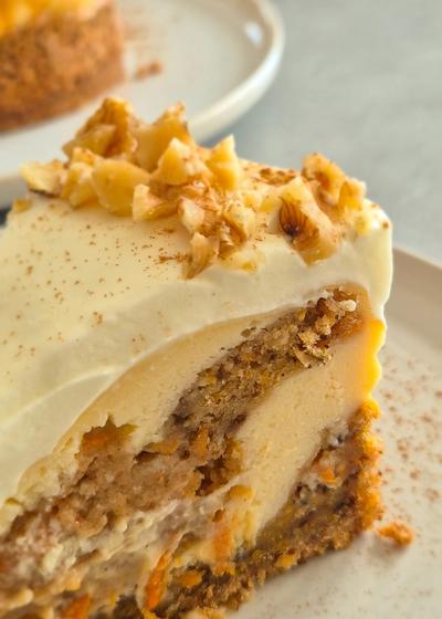 Cremiger Carrot Cake Cheesecake mit leckerem Frosting wie aus den USA auf einem Teller serviert.