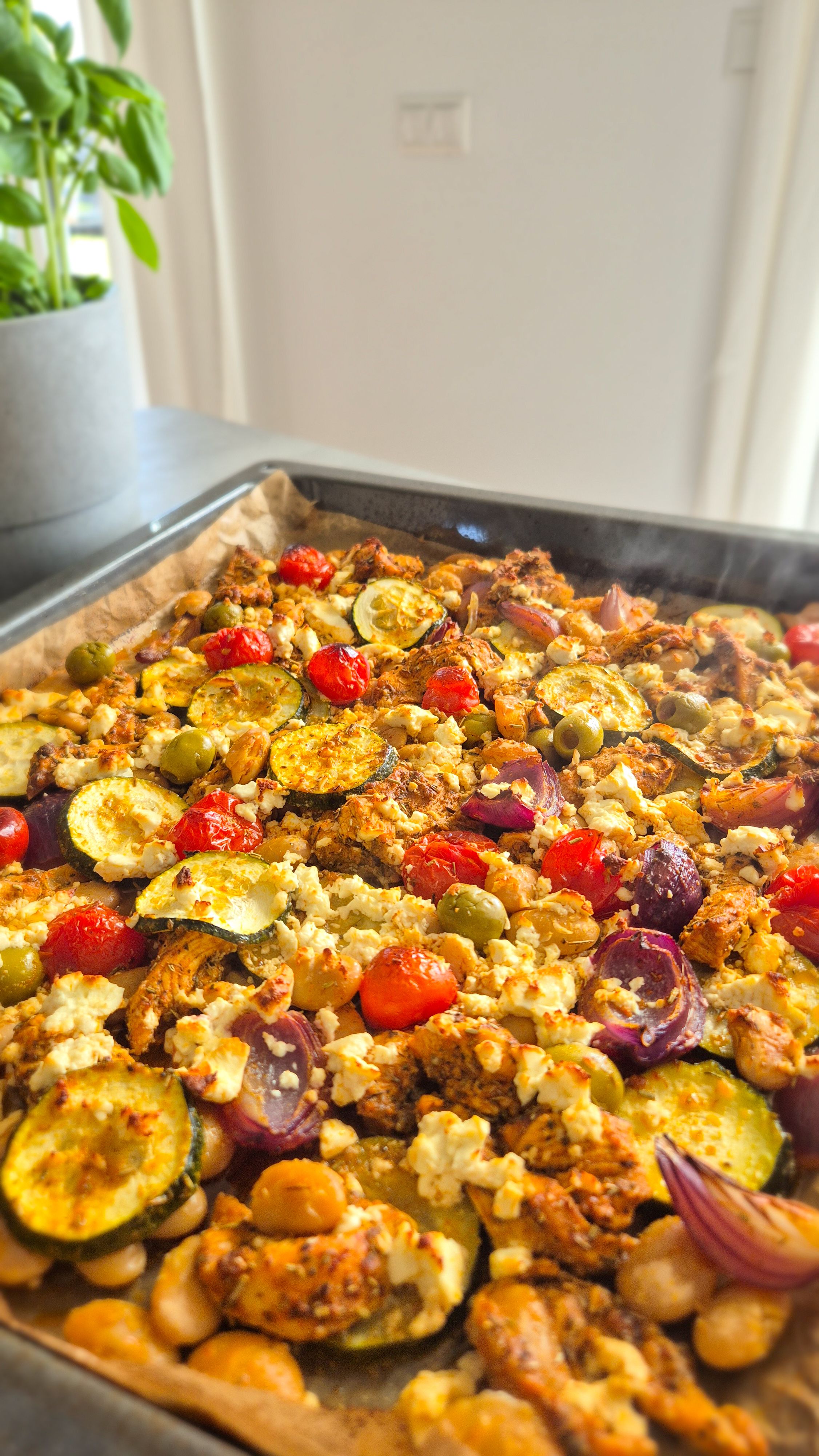 Griechisches Gemüse mit Hähnchen auf einem Blech.