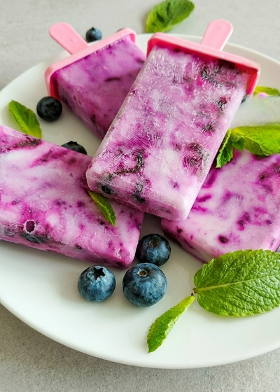 Selbstgemachtes Joghurt-Eis am Stiel mit Heidelbeeren.