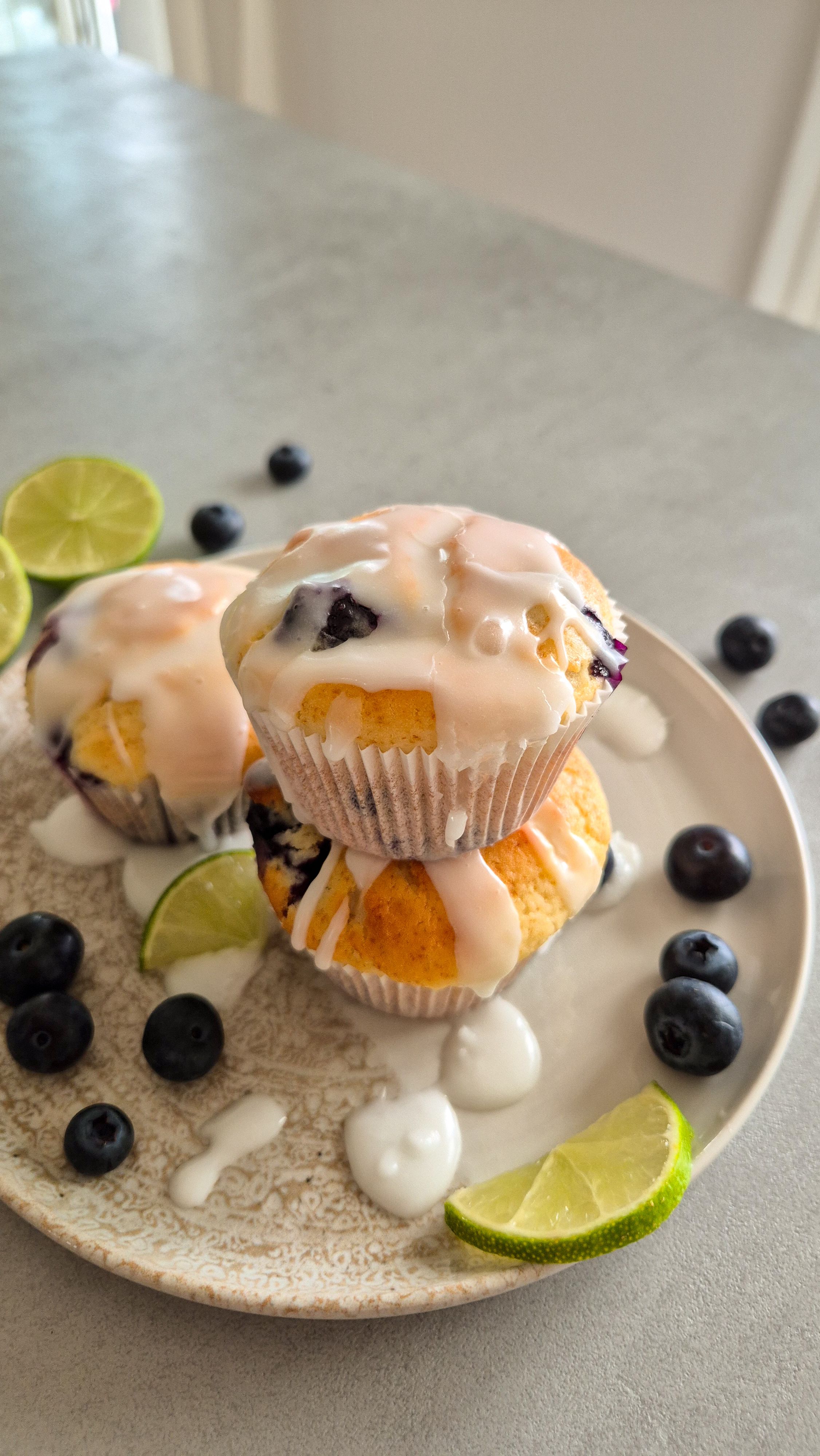 Saftige Zitronen-Heidelbeer-Muffins mit Joghurt auf einem Teller serviert.