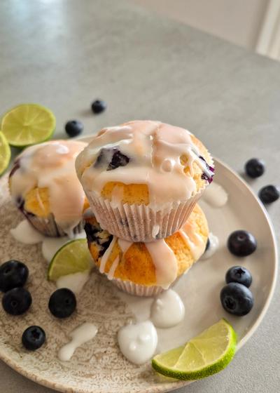 Saftige Zitronen-Heidelbeer-Muffins mit Joghurt auf einem Teller serviert.