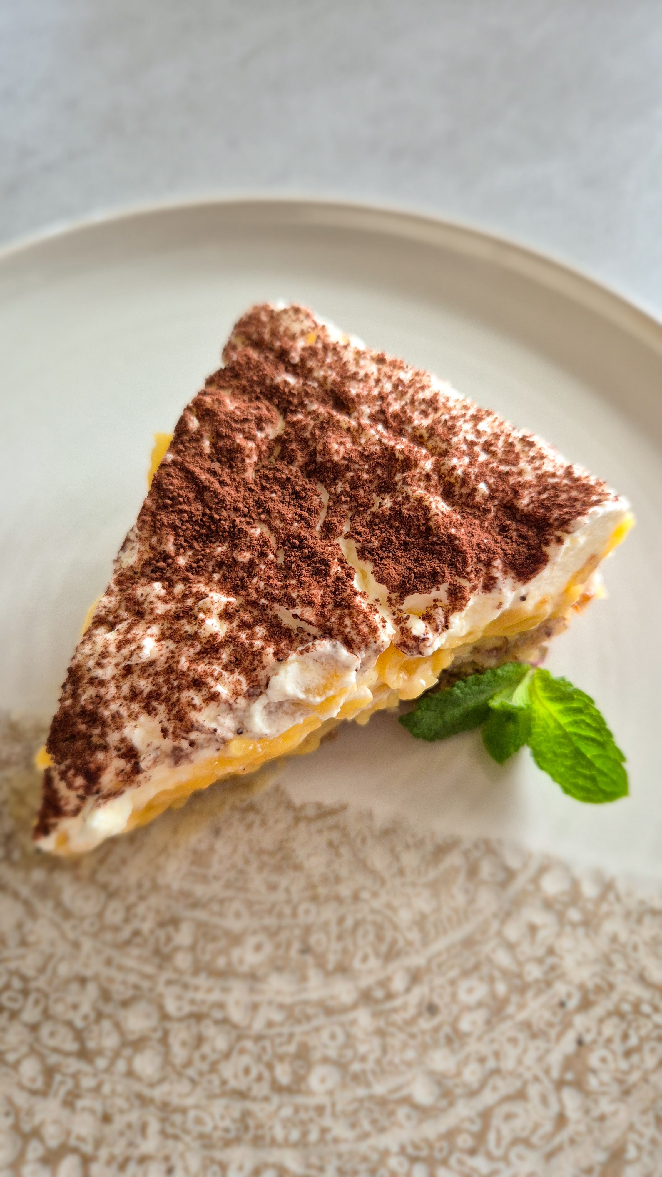 Ein Stück saftige schwedische Apfeltorte mit einer dicken Haube aus Mascarpone-Sahne auf einem Vintage-Teller