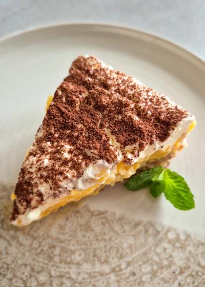 Ein Stück saftige schwedische Apfeltorte mit einer dicken Haube aus Mascarpone-Sahne auf einem Vintage-Teller
